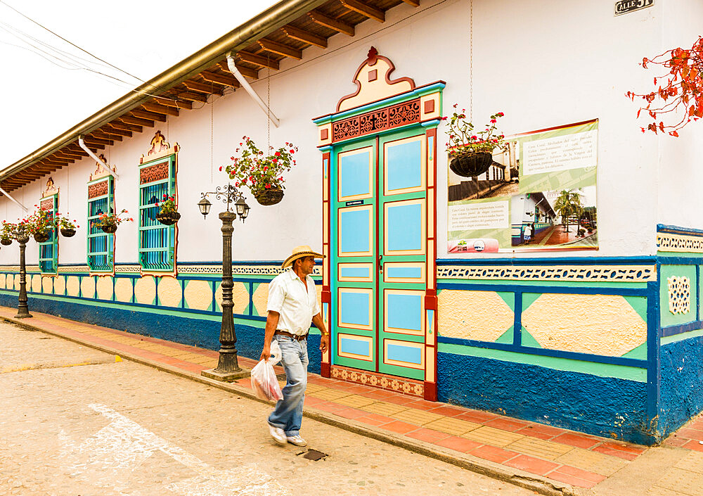 A typically colourful street with buildings covered in traditional local tiles in the picturesque town of Guatape, Colombia, South America