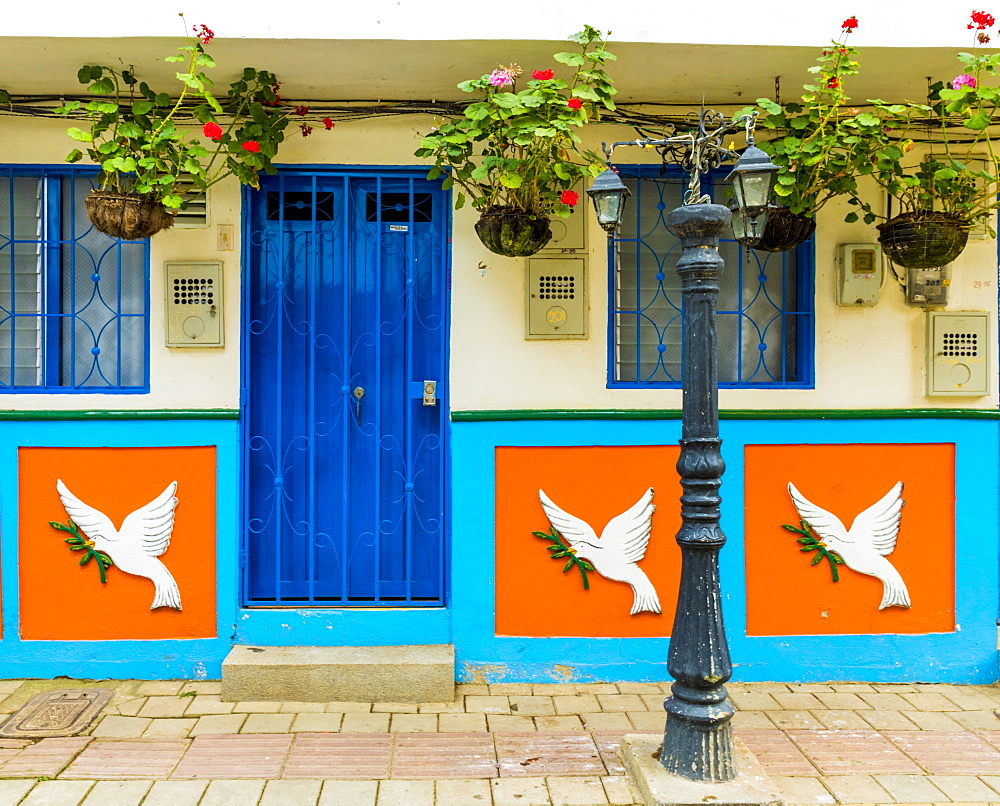 The facade of a colourful building covered in traditional local tiles, in the picturesque town of Guatape, Colombia, South America