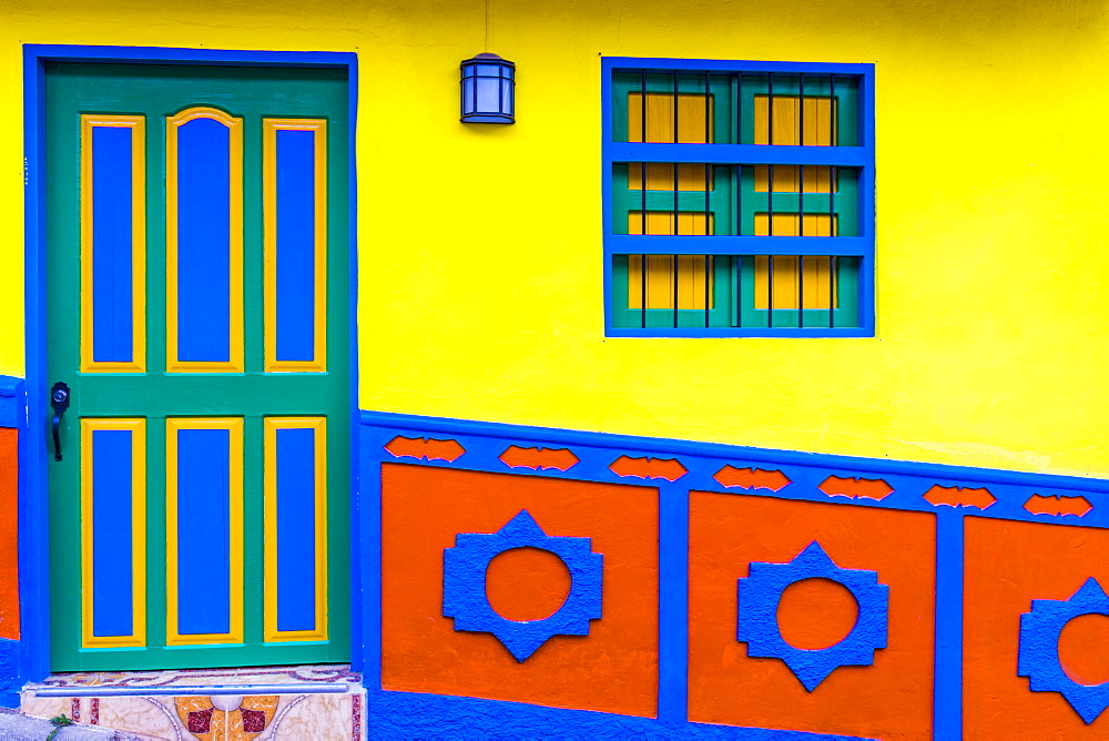 The facade of a colourful building covered in traditional local tiles, in the picturesque town of Guatape, Colombia, South America