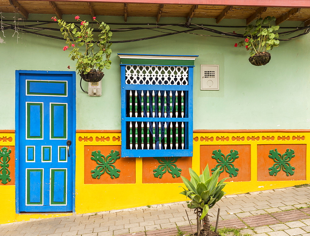 The facade of a colourful building covered in traditional local tiles, in the picturesque town of Guatape, Colombia, South America