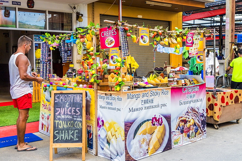 A tourist at a colourful pancake stall in Kata, Phuket, Thailand, Southeast Asia, Asia