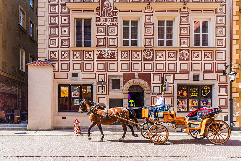 A horse drawn carriage passing beautiful architecture in the old town, UNESCO World Heritage Site, Warsaw, Poland, Europe