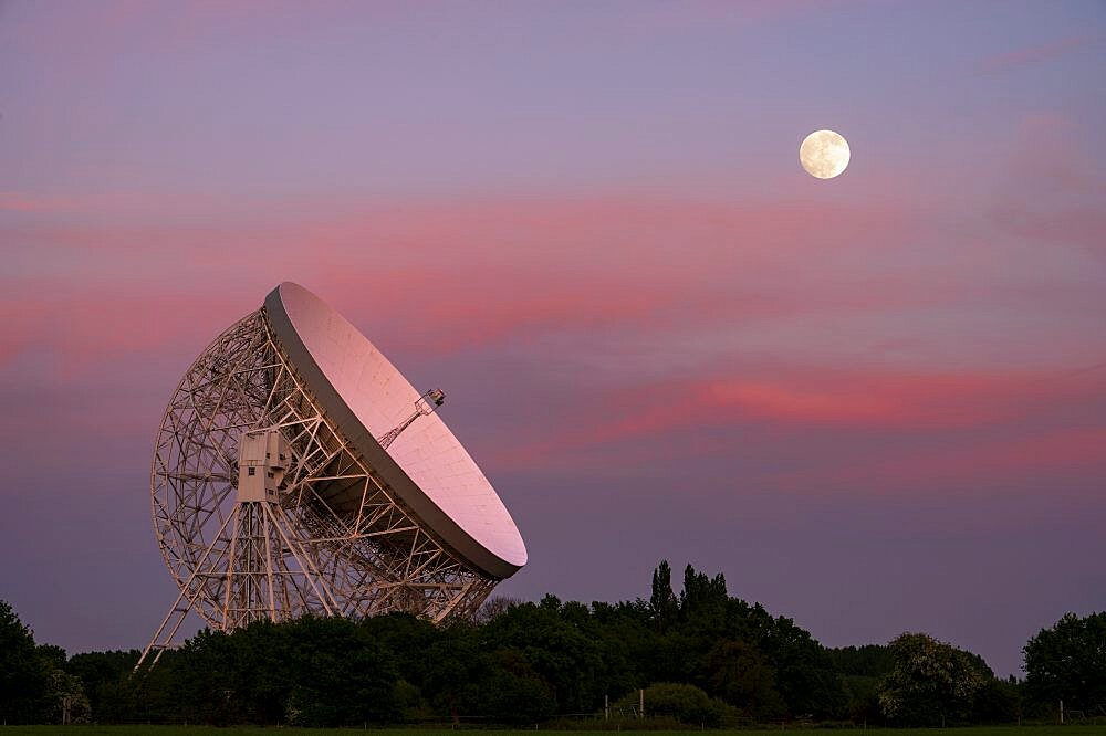 The Lovell Mark I Giant Radio Telescope at night with perfect alignment with the full moon, Jodrell Bank, Cheshire, England