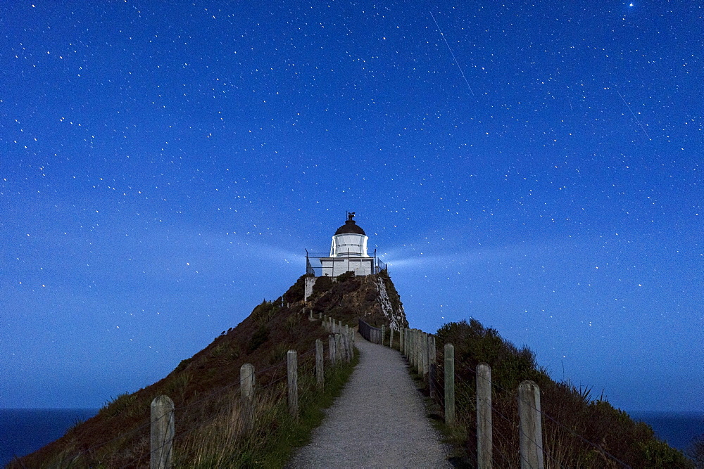 Nugget Point lighthouse under star filled sky, Kaka Point, Otago, South Island, New Zealand, Pacific