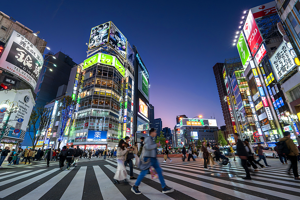 Pedestrians crossing on busy road at night, Shinjuku district, Tokyo, Japan