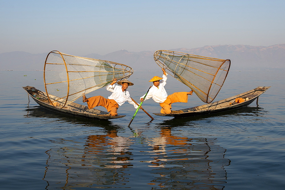 Two Intha leg rowing fisherman holding up fishing nets, Inle Lake, Shan State, Myanmar (Burma), Asia