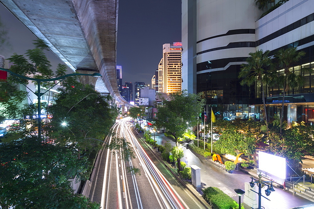 View of elevated skytrain track and traffic light trails on Sukhumvit Road in downtown Bangkok, Thailand, Southeast Asia, Asia