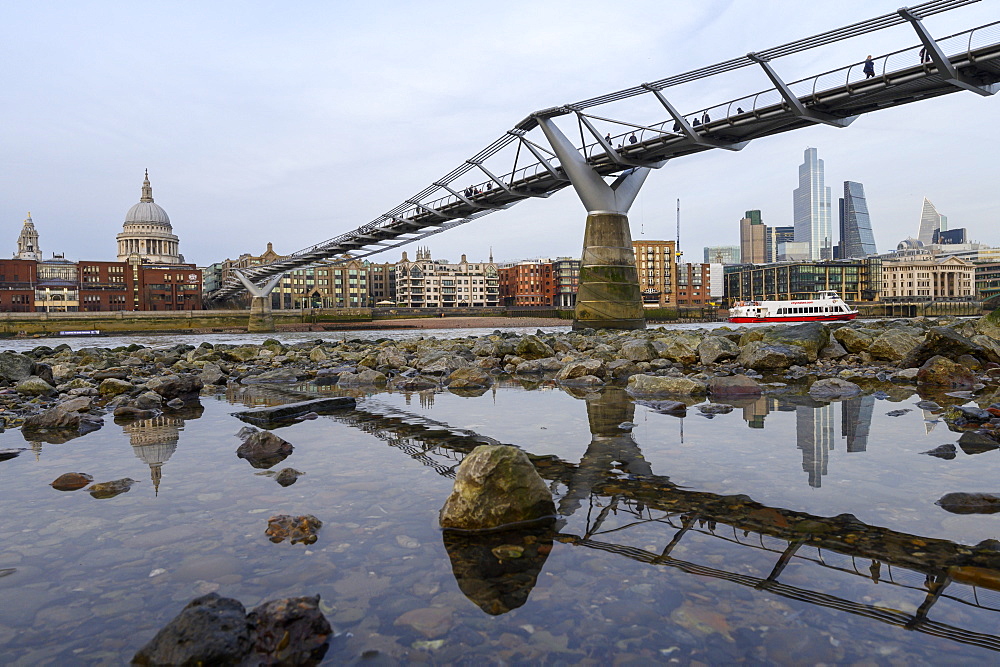 Millennium Bridge and city overview at low tide on River Thames, London, England, United Kingdom, Europe