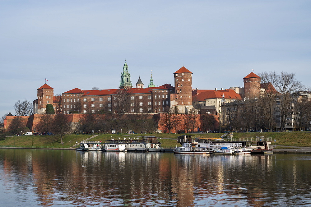 View to Wawel castle, UNESCO World Heritage Site, with restaurant boats moored on Wista (Vistula) River in riverside park, Krakow, Poland, Europe