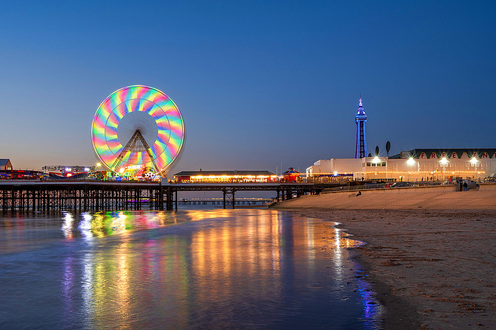 Big wheel and amusements on Central Pier at sunset with Blackpool Tower, Blackpool, Lancashire, England, United Kingdom, Europe