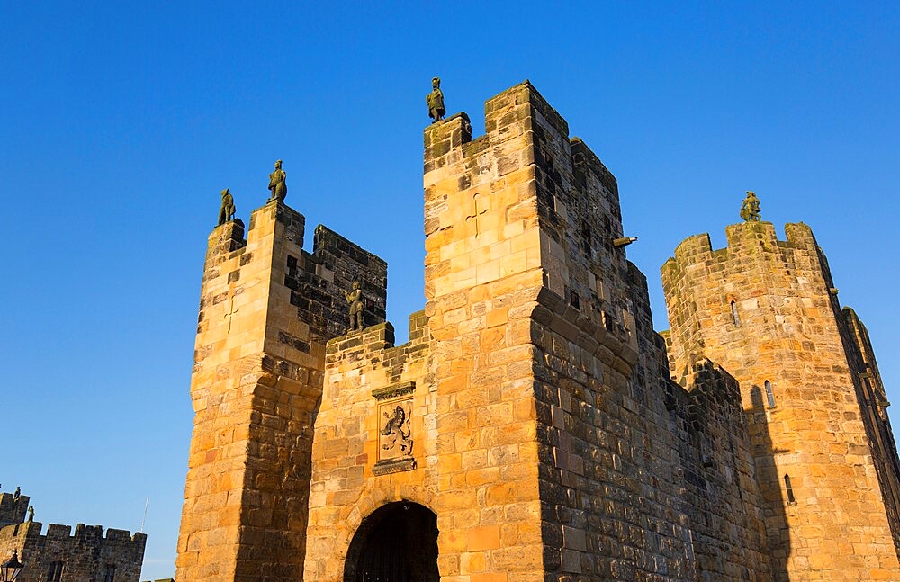 The medieval barbican and gatehouse of Alnwick Castle, sunset, Alnwick, Northumberland, England, United Kingdom, Europe