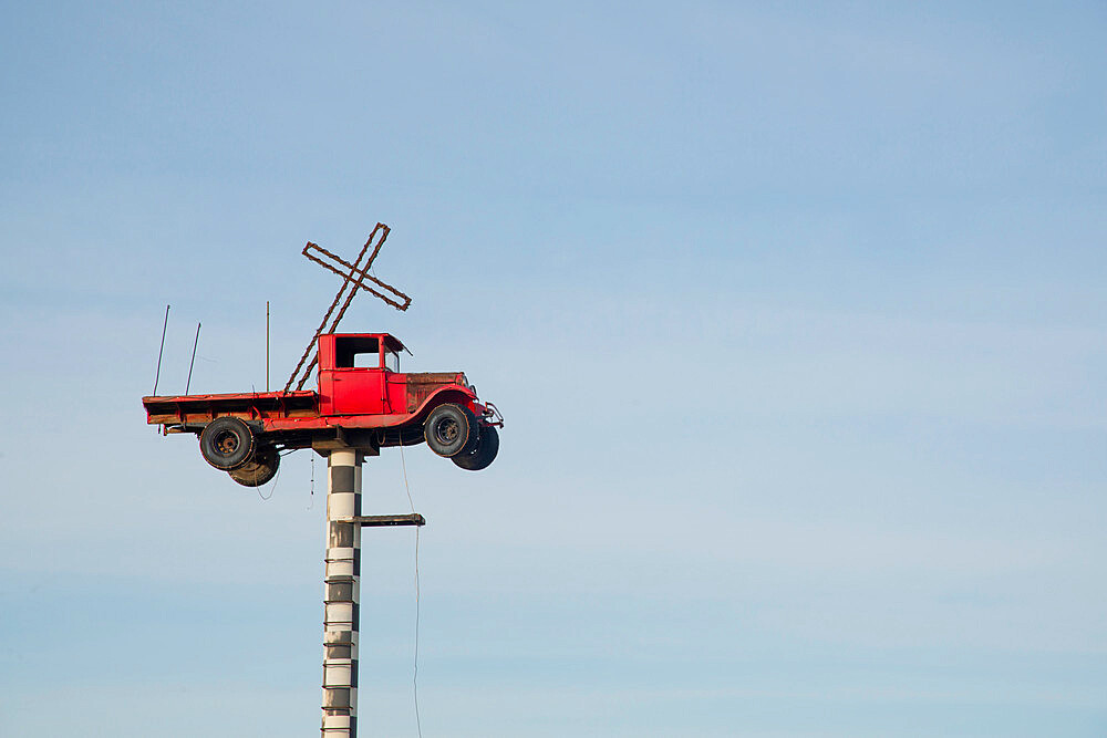 Vintage truck with a cross in the back suspended on a pole in New Mexico, United States of America, North America