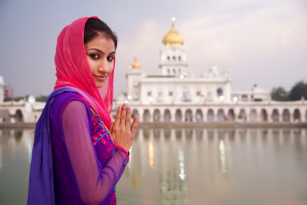 A young woman worshipping at a Sikh temple in Delhi, India, Asia