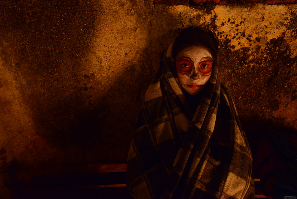 Zapotec girl holding candle among graves adorned with marigolds, Atzompa, Oaxaca, Mexico, North America