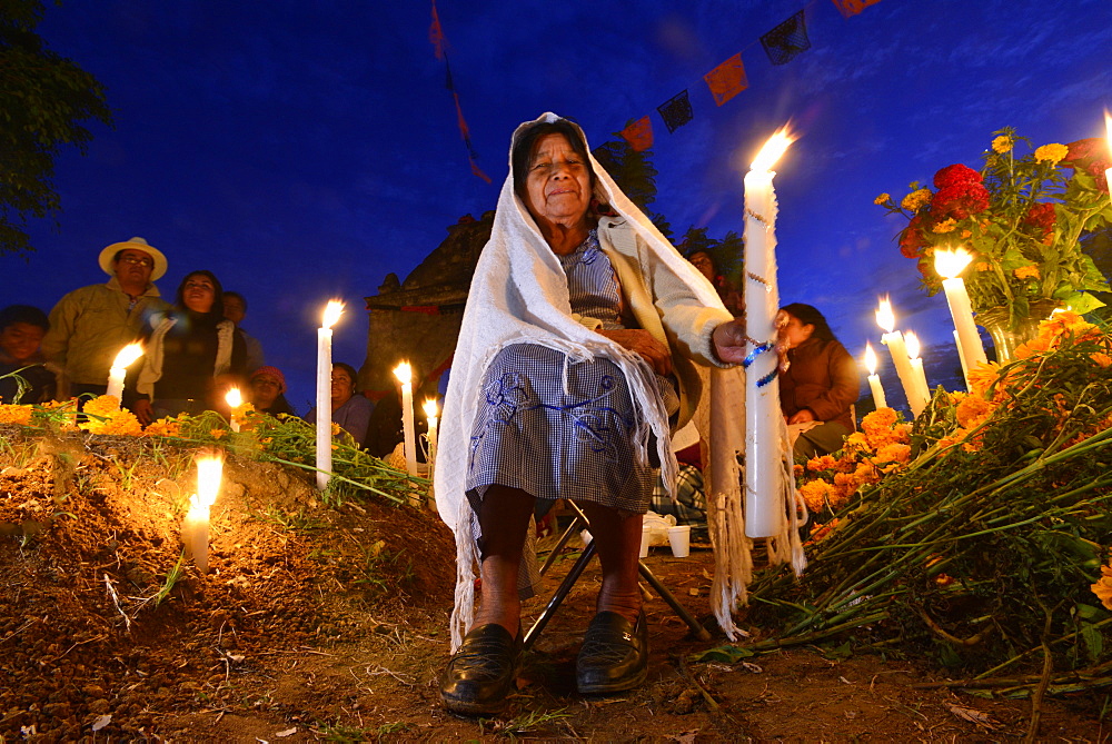 Zapotec woman holding candle among graves adorned with marigolds, Atzompa, Oaxaca, Mexico, North America