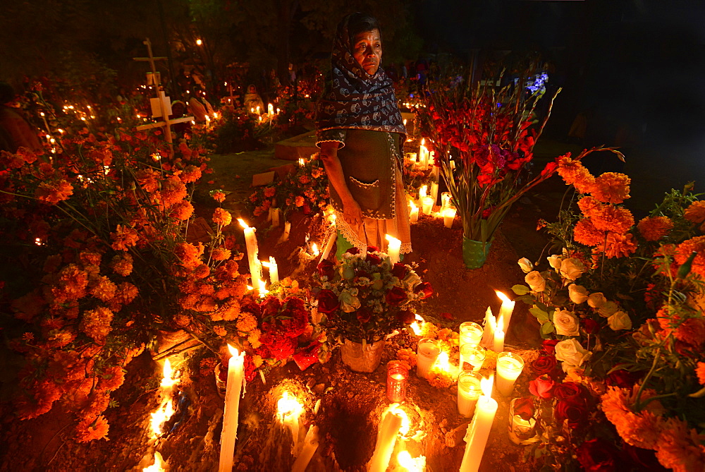 Zapotec woman holding candle among graves adorned with marigolds, Atzompa, Oaxaca, Mexico, North America