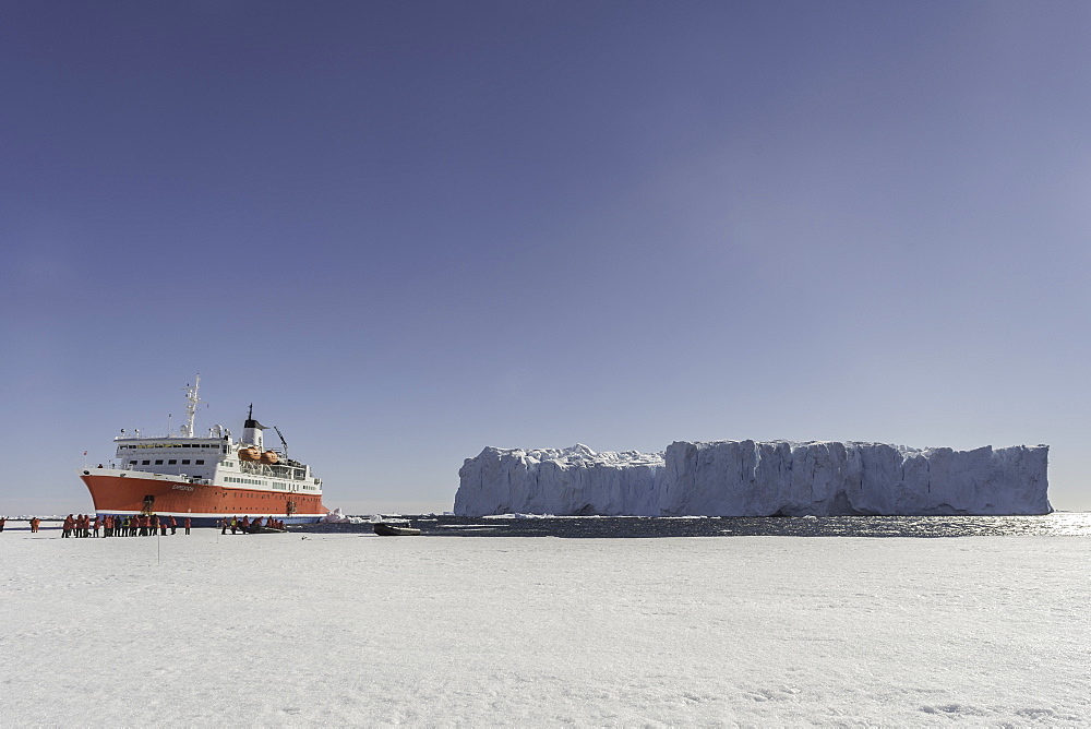 Large iceberg and expedition ship against sea ice, Antarctica, Polar Regions