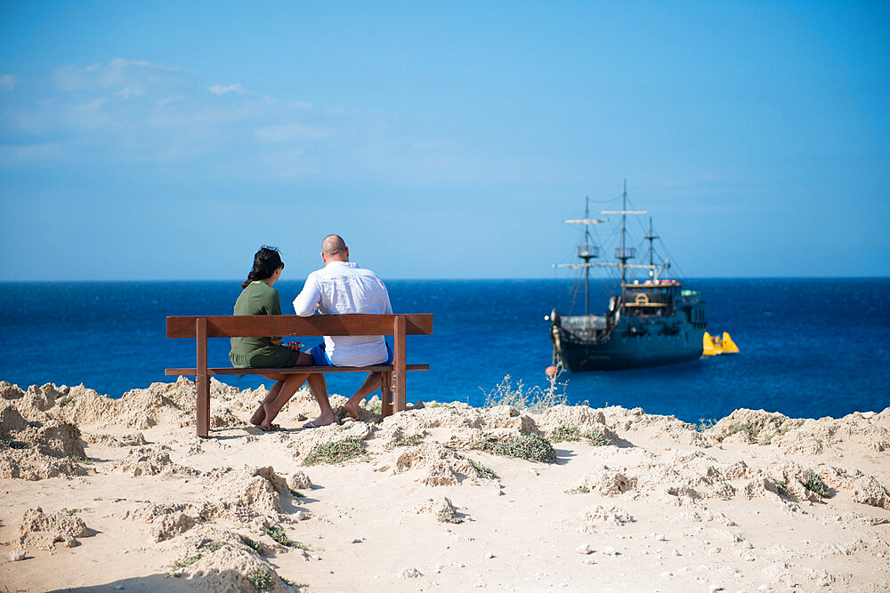 Couple sat overlooking a themed pirate ship, Cape Greco, Protaras, Cyprus, Mediterranean, Europe