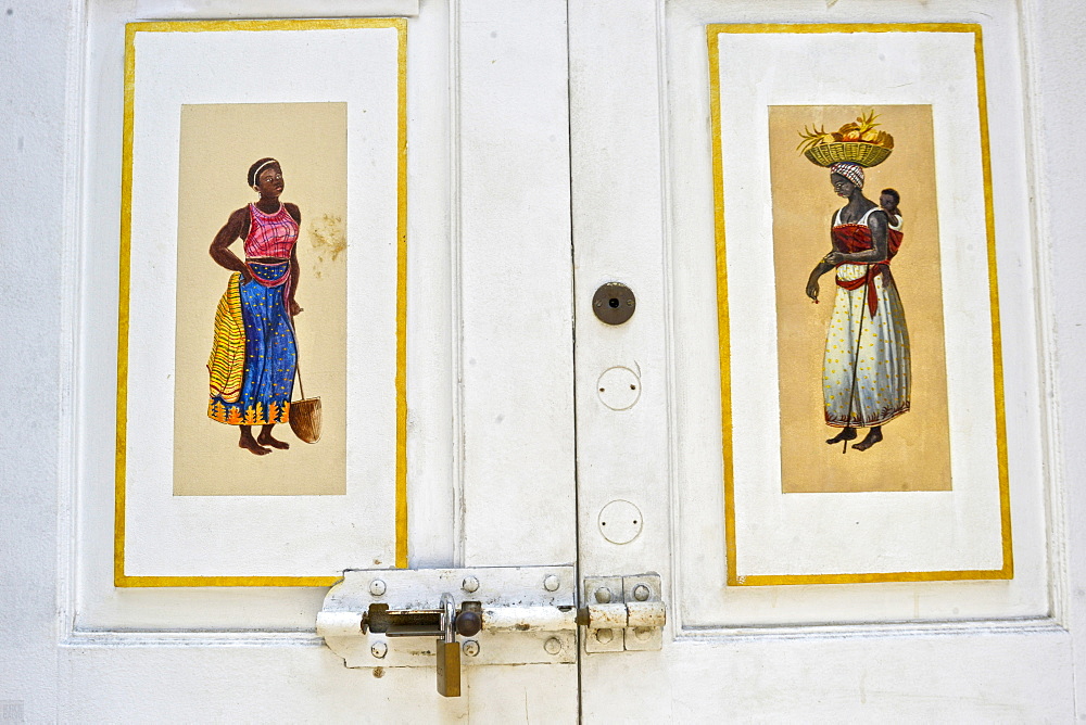 Afro-Brazilian paintings in a white wooden door at Travessa do Comercio, Brazil