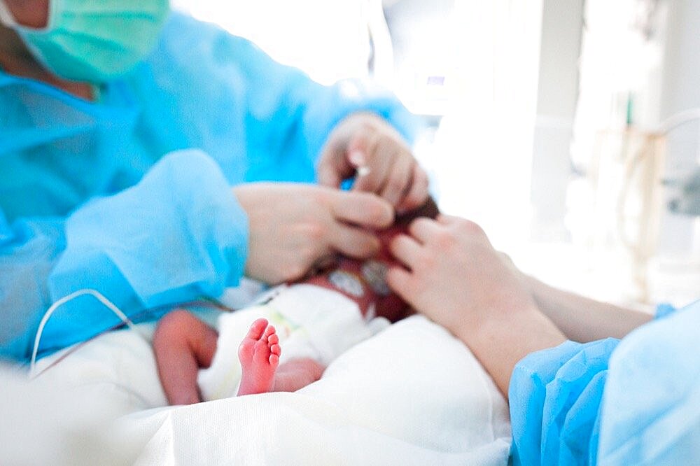 A nursery nurse takes care of a premature baby. Hospital. Aix en Provence.