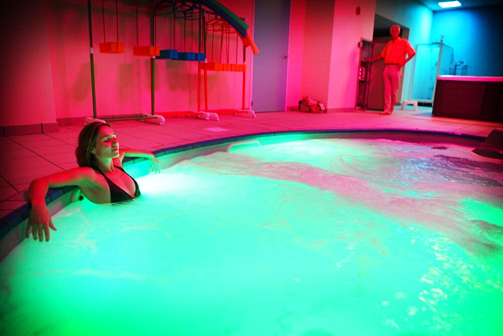 Reportage in the Chrysalide wellness centre in France that specialises in chromotherapy. A colour profile is defined for each patient and can be applied to each part of the spa. A patient receives chromotherapy treatment in a swimming pool.