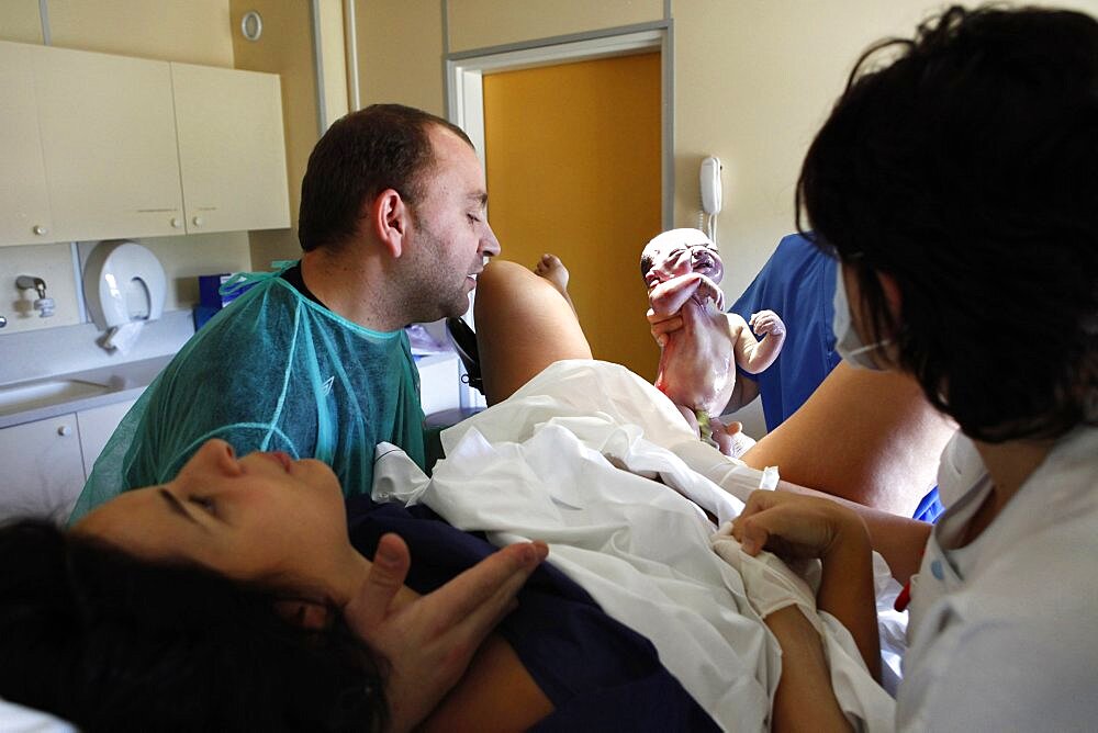 Woman with husband giving birth in hospital