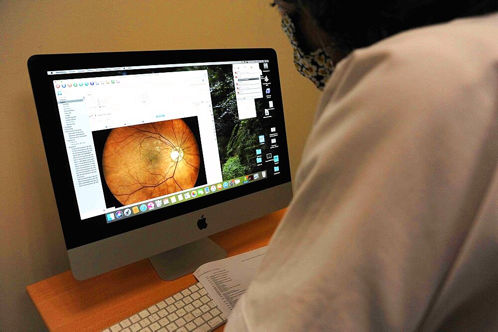 Ophthalmology office. Masked patient and doctor - Covid 19 in consultation. Refractive telescope, slit lamp, fundus, AMD, eye diabetes, retinal scanner, Volk lens, Cover test, glasses, blur. Old person.