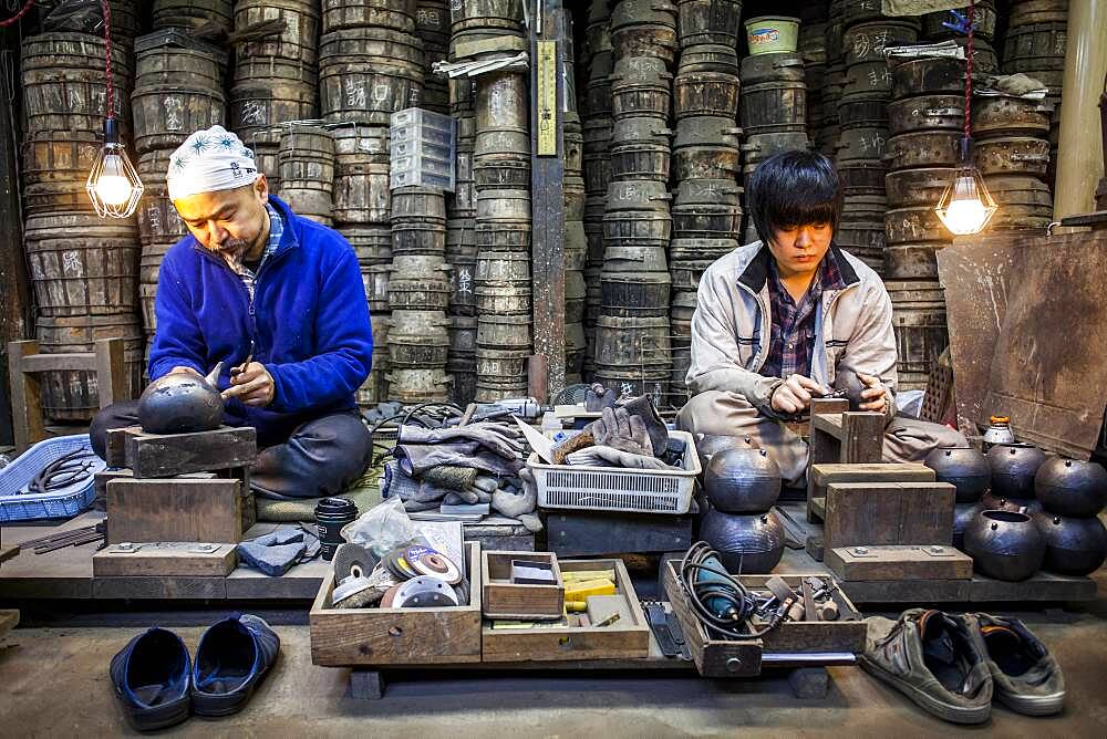 artisans are putting the finishing touches at iron teapots or tetsubin, nanbu tekki, in Workshop of Morihisha Suzuki,craftsmen since 1625, Morioka, Iwate Prefecture, Japan