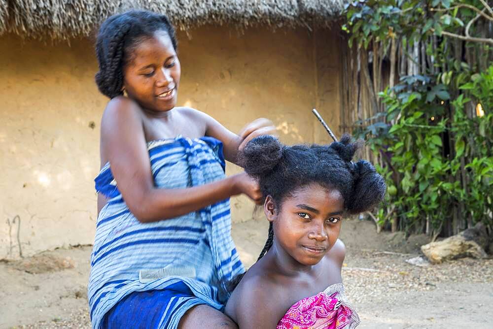 Young girls, friends arranging their hair, small town in the Tsingy de Bemaraha National Park. Madagascar, Africa