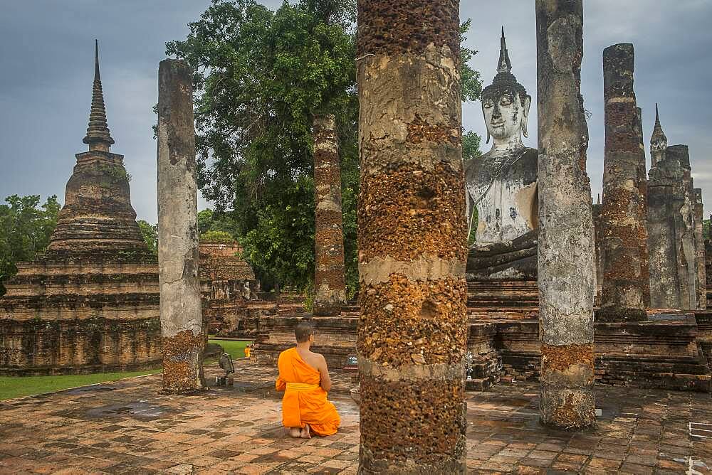 Monk praying, in Wat Mahathat, Sukhothai Historical Park, Sukhothai, Thailand