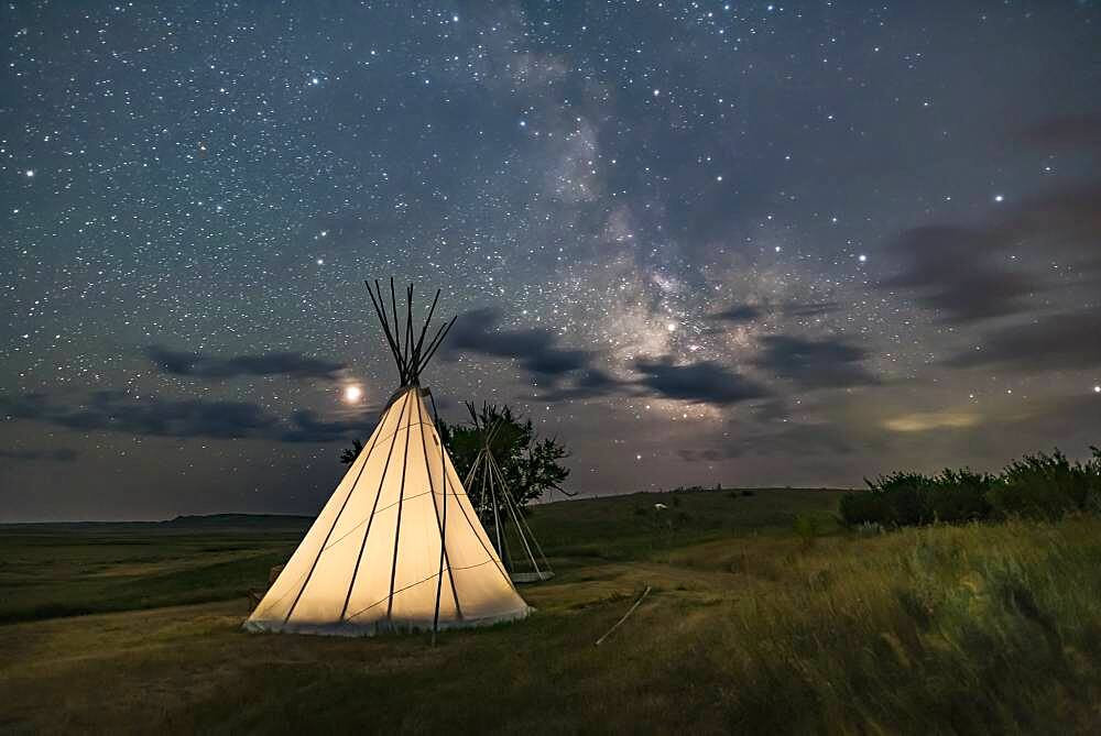 Mars (at left) and the Milky Way (at right) over a single tipi (with another under construction at back) at the Two Trees site at Grasslands National Park, Saskatchewan, August 6, 2018. I placed a low-level warm LED light inside the tipi for the illumination.