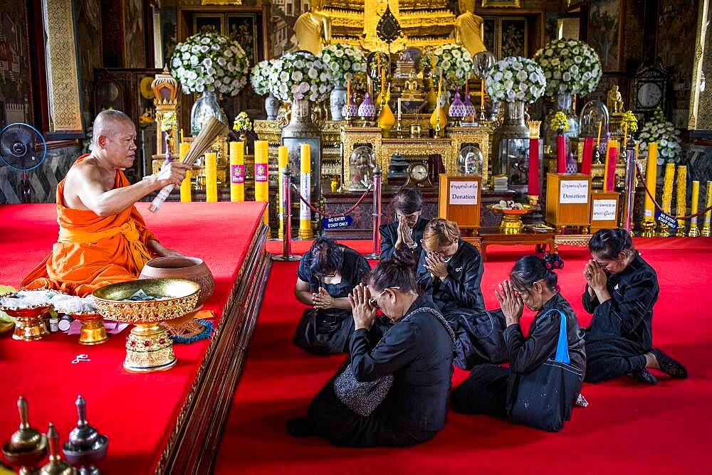 Monk blessing women, in Wat Arun (Temple of Dawn), also called Wat Bangmakok Noek, Bangkok, Thailand