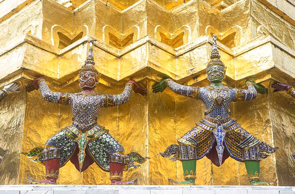 Statues of demons on a Golden Chedi,  at the temple of the Emerald Buddha Wat Phra Kaeo, Grand Palace, Bangkok, Thailand