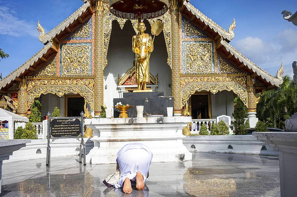 woman praying, in Wat Phra Singh temple, Chiang Mai, Thailand