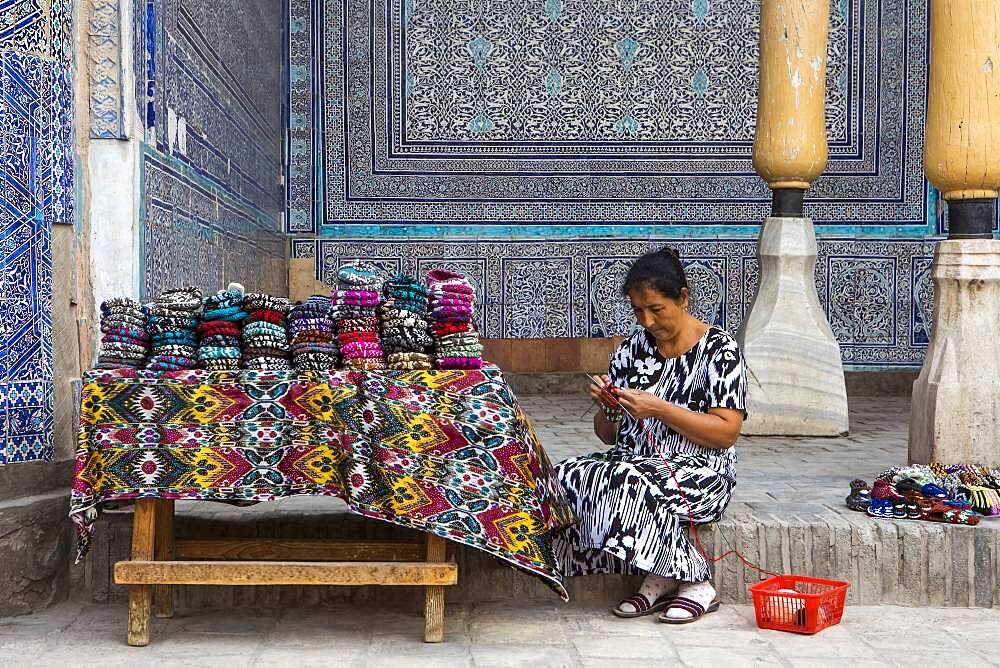 Vigilant who also sells knitwear made by her, in Summer Mosque, inside Kuhna Ark, Khiva, Uzbekistan