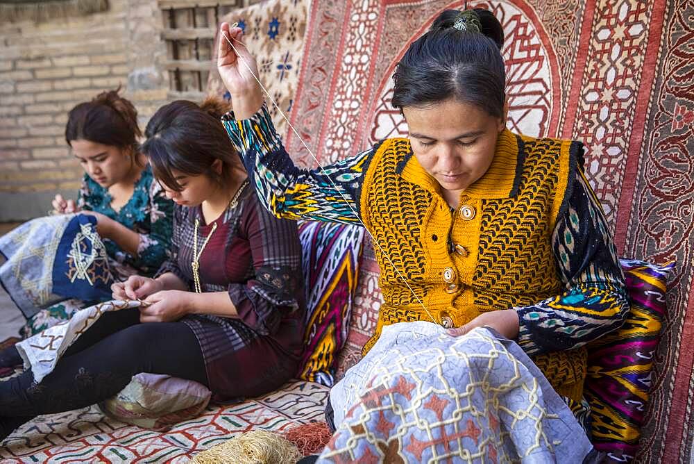 Craftswomen making embroideries, workshop in Yoqubboy Hoja medressa, Khiva, Uzbekistan