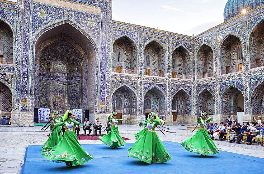 Traditional dance, folklore, in the courtyard of Sher Dor Medressa, Registan, Samarkand, Uzbekistan