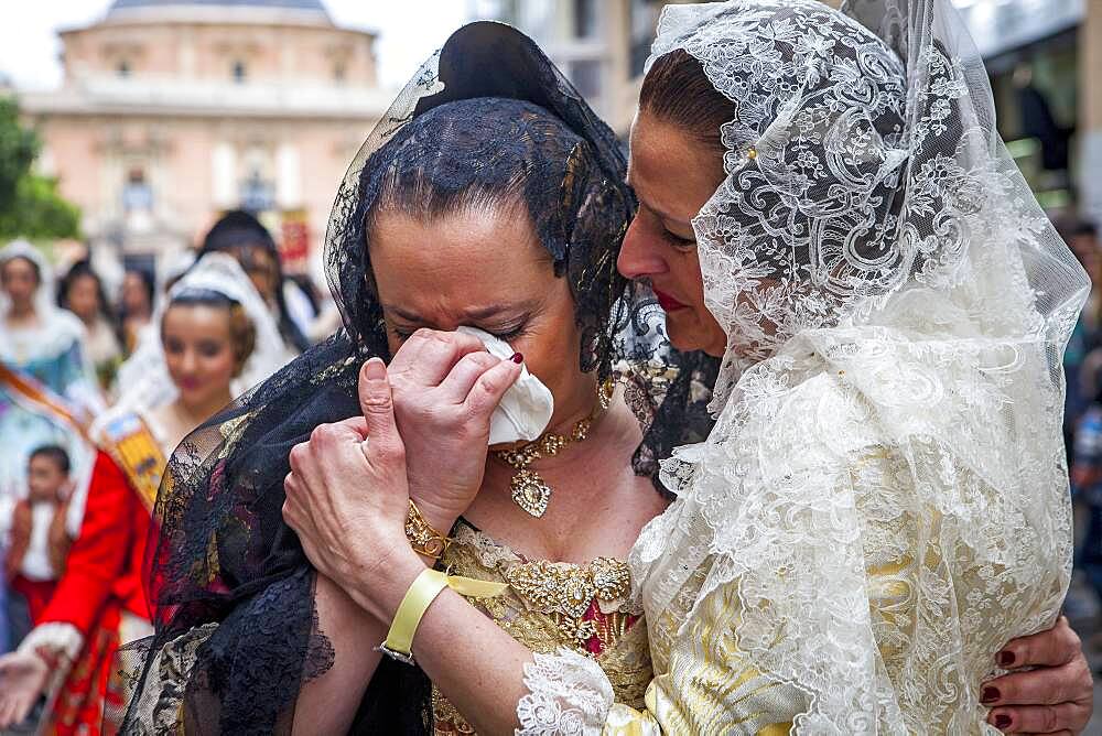 After seeing the Virgin, women in Fallera Costumes crying during Flower offering parade, tribute to `Virgen de los desamparados��, Fallas festival, Plaza de la Virgen square,Valencia