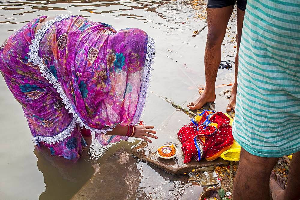 Woman making offering, in the ghats of Ganges river, Varanasi, Uttar Pradesh, India.