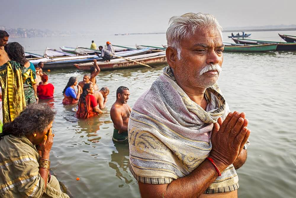 Pilgrims praying and bathing, in the ghats of Ganges river, Varanasi, Uttar Pradesh, India.