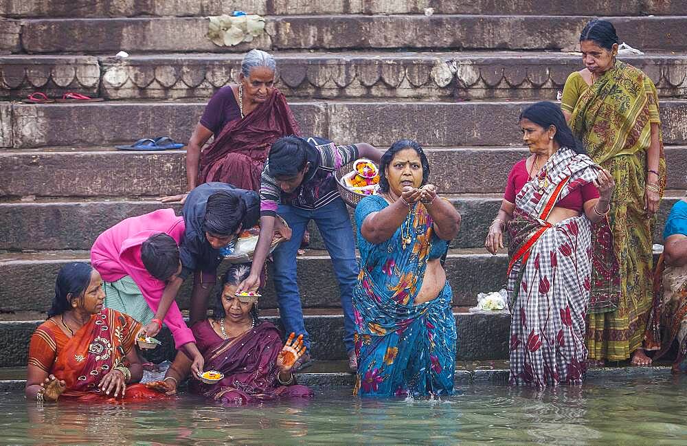 Pilgrims praying and bathing, in the ghats of Ganges river, Varanasi, Uttar Pradesh, India.