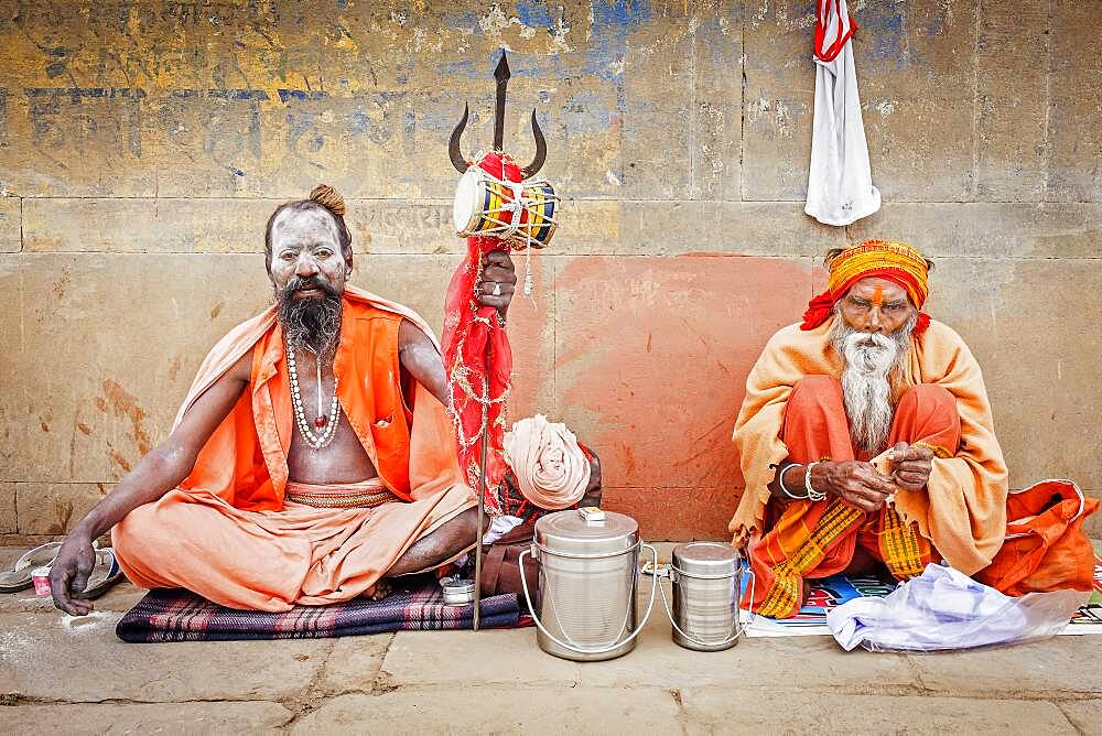 Sadhus praying and begging, in the ghats of Ganges river, Varanasi, Uttar Pradesh, India.