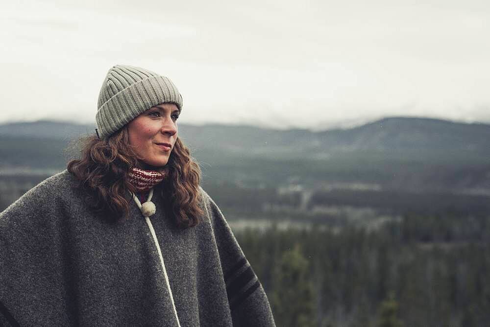 A 30 year old brunette lets her view wander above the valley. Yukon Territory, Canada