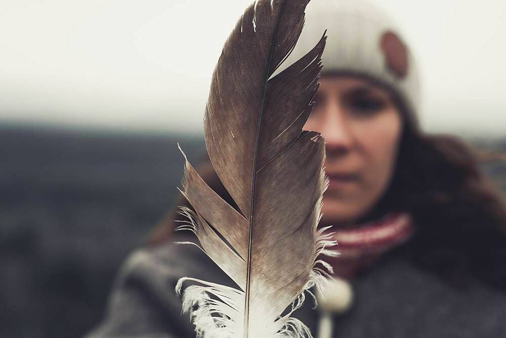 A young Woman shows an eagle's feather. Yukon Territory, Canada