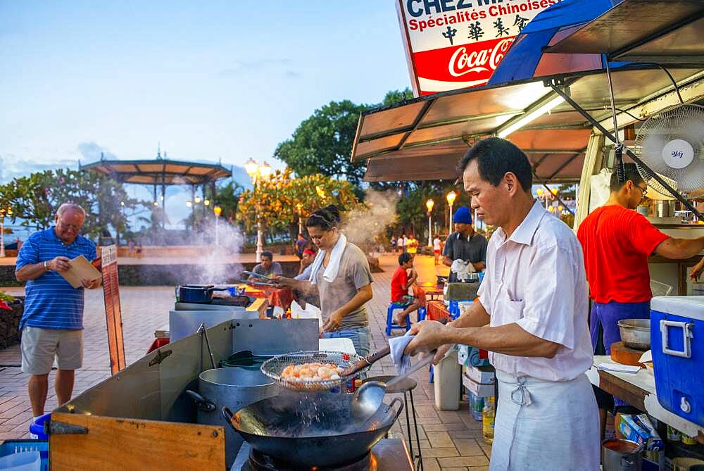 Outdoor dining in a plaza among roulotte food vans at Papeete on the island of Tahiti, Tahiti Nui, Society Islands, French Polynesia, South Pacific.