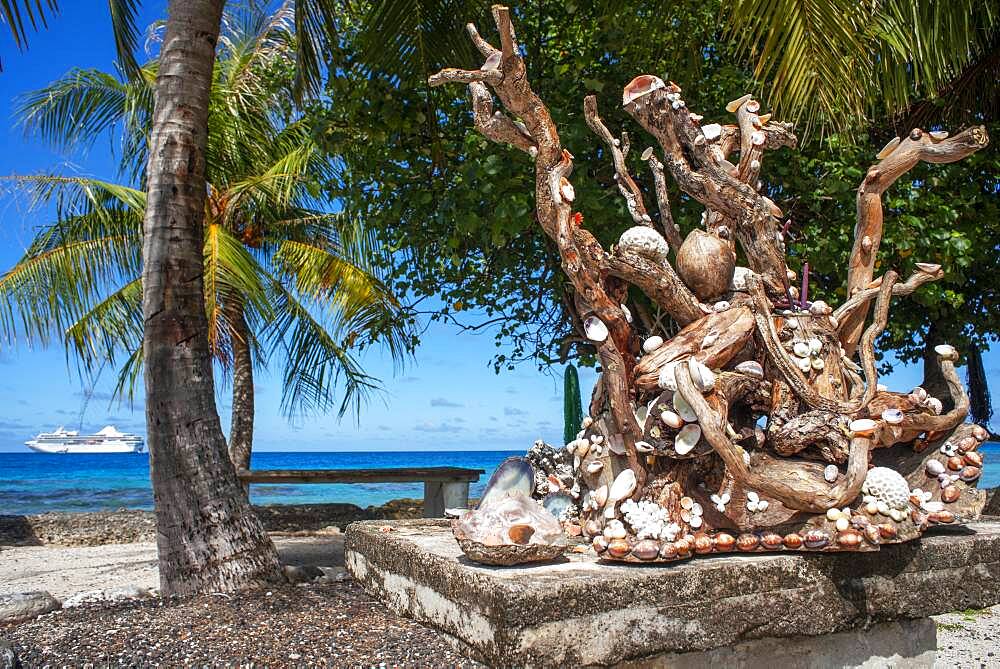 A sculpture with shells on a railing overlooking a tropical lagoon on the island of Fakarava in French Polynesia