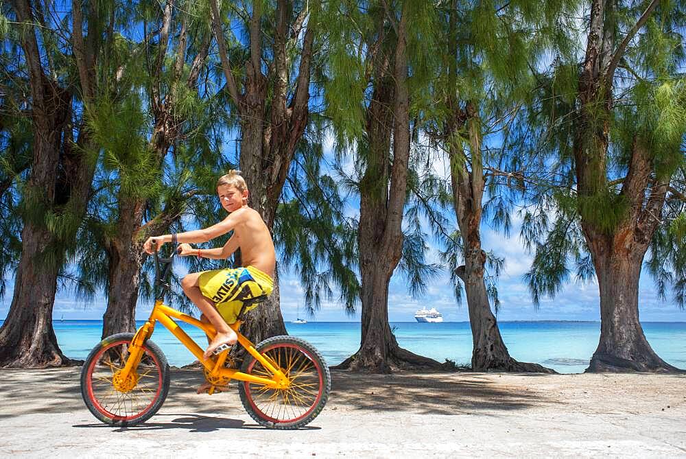 Tourist boy with a bike in Fakarava,  Tuamotus Archipelago French Polynesia, Tuamotu Islands, South Pacific.