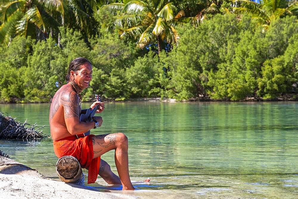 Island of Taha'a, French Polynesia. A local boy plays the ukulele to woo your girl at the Motu Mahana, Taha'a, Society Islands, French Polynesia, South Pacific.