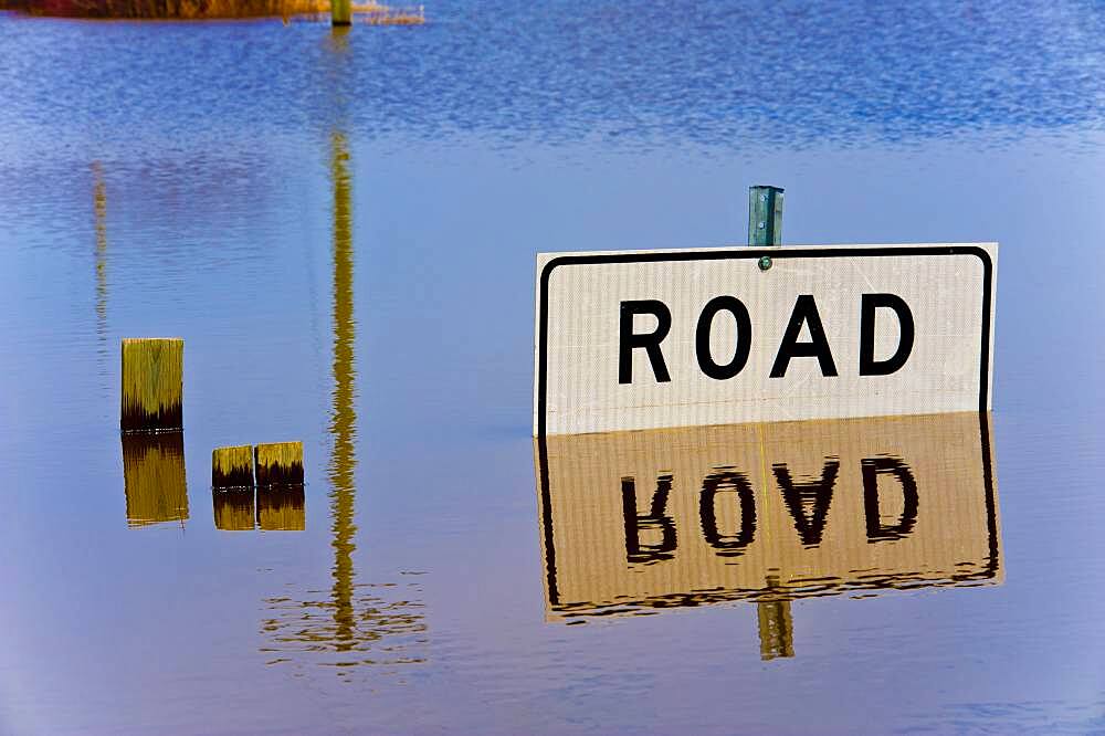 Road closed sign reflected in flood waters.