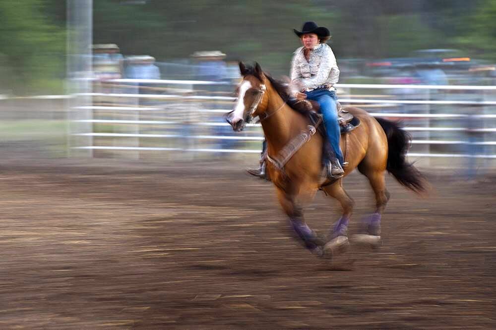 Horse and rider in rodeo barrel racing event.